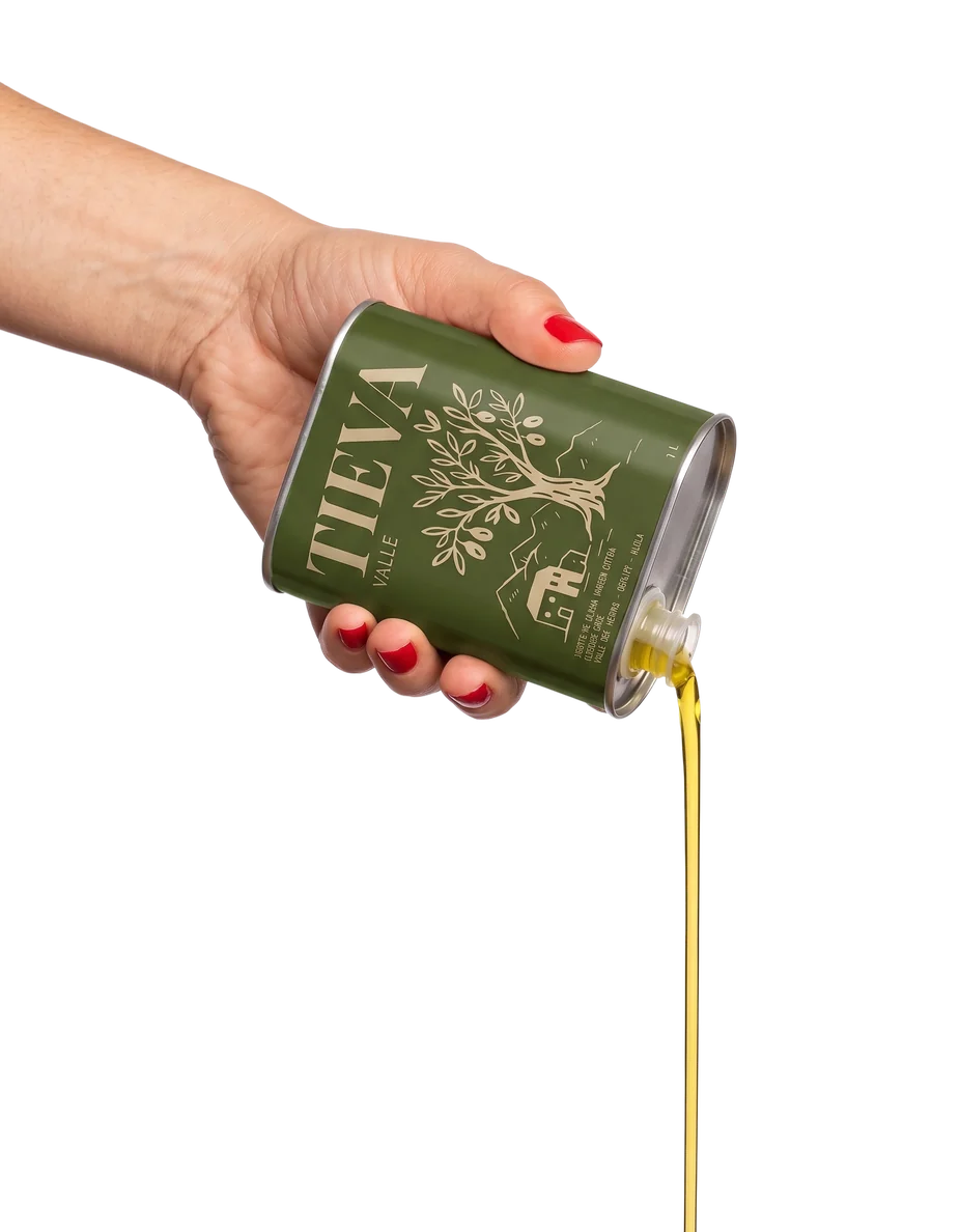 Una mano vierte aceite desde la lata Valle